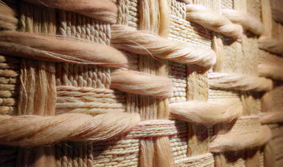 Close-up of textured handwoven textile with thick natural fibers in warm earthy tones