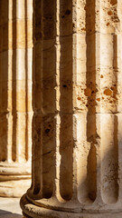 Close-up of ancient stone columns with warm sunlight and textured surfaces in classical architectural detail