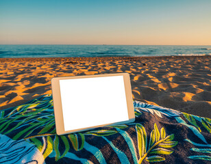 Tablet on beach towel at Firefly Beach with sand and ocean in the background