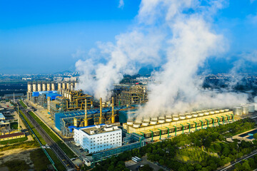 Aerial view of large chemical plant and oil refinery with cooling tower steam in industrial area