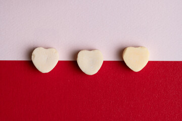 Row of Yellow Candy Hearts on Red Background
