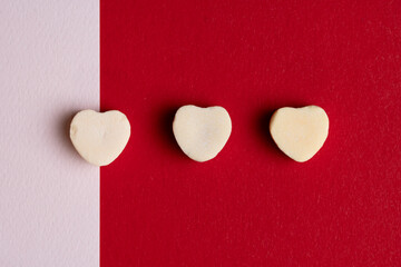 Three White Candy Hearts on Red Background