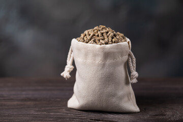 Combination feed in the form of bird pellets in a bag on a wooden table, authentic photograph, not AI-generated