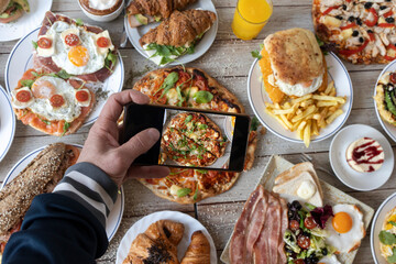 Hand shooting top view sharing brunch food on smartphone