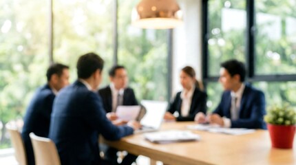 A blurred background image featuring a group of business professionals seated around a conference table in a sunlit meeting room, discussing important matters.