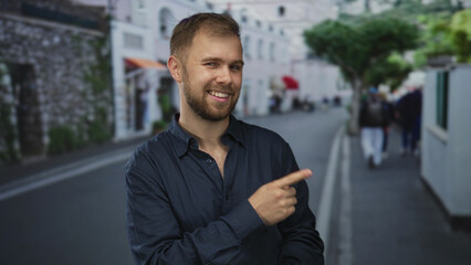 Man pointing finger on city street while making a dismissive hand gesture, beard visible and wearing navy shirt; playful confidence.