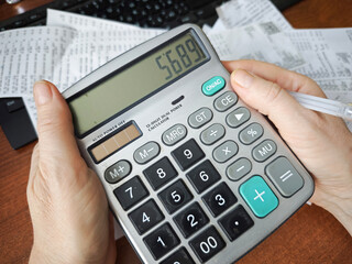 Calculator, receipts and handwritten calculations on desk, budgeting, expense tracking, financial accounting, household finance concept