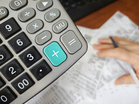 Calculator, receipts and handwritten calculations on desk, budgeting, expense tracking, financial accounting, household finance concept