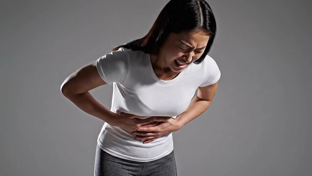 Young woman experiencing severe stomach pain and discomfort.