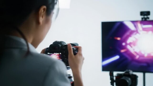 Skilled creative in business-casual, focused on digital content in a sleek studio with pro cameras & monitors, diffused light, shallow DOF, concept of professional media production