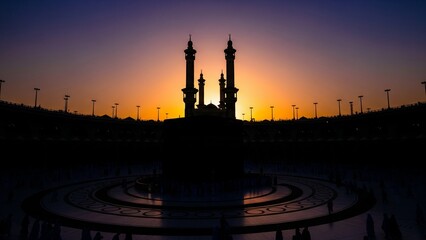 Holy Kaaba in Masjid Al-Haram, Mecca, Saudi Arabia during sunset with silhouette of minarets