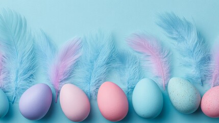 Top view of colorful easter eggs and blue feathers on pastel blue background, spring holiday decoration concept