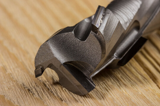diamond woodworking cutter on a wooden background in close-up. carbide cutter. cnc tool.
