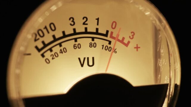 A close-up of an analog VU meter shows the needle fluctuating, measuring a sound signal's volume. Concept of vintage audio technology, sound engineering, broadcasting, and precise measurement.
