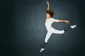Ballet, jump and space with dancer woman in studio for choreography practice or rehearsal. Dance, energy and mockup with serious ballerina person on dark background for exercise, fitness or wellness