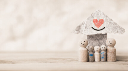 Fototapeta premium Whimsical Family Representation Under A Heart Roof With Smiling Faces On Wooden Surface In Soft Lighting
