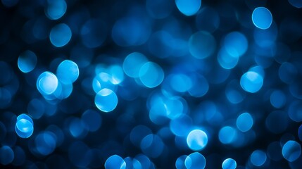 Abstract blue bokeh lights on black background with soft glow