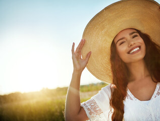 Fototapeta premium Portrait, woman and smile for travel outdoor with peace, fresh air and calm morning on holiday. Space, female person and vacation with straw hat in field, weekend break and summer trip in countryside