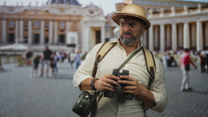 Man holding binoculars, grimacing with hands visible at building in st peters square; travel...