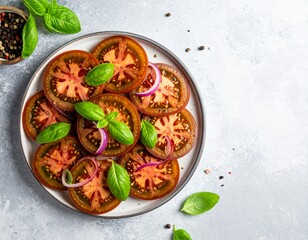 Fresh Tomato and Basil Salad with Red Onion on a White Plate.