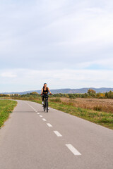 Obraz premium Active woman cycling on rural road in summer
