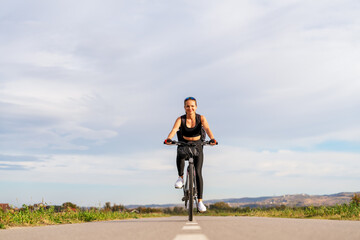 Obraz premium Female cyclist traveling through rural area in summer