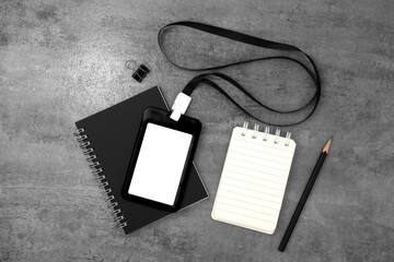 Black plastic badge with book and note on stone texture background. Template designed for employees of company