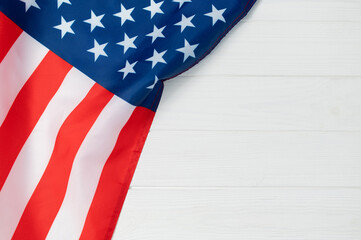 American flag fabric USA showing stars and stripes on a white wooden background, representing national identity, democracy, and celebration copy space