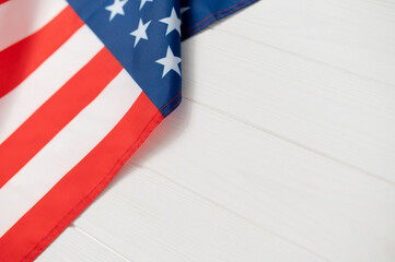 American flag fabric USA showing stars and stripes on a white wooden background, representing national identity, democracy, copy space and celebration