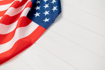 American flag fabric USA showing stars and stripes on a white wooden background, representing national identity, democracy, and copy space celebration