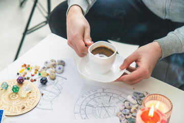 Tasseography: empty coffee cup, natal charts, runes and magic stones on table