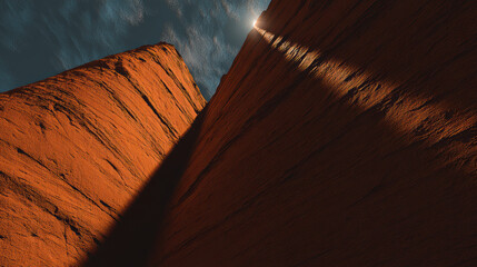 Sunlit narrow sandstone canyon with warm orange rock walls and dramatic shadow creating serene, awe inspiring mood