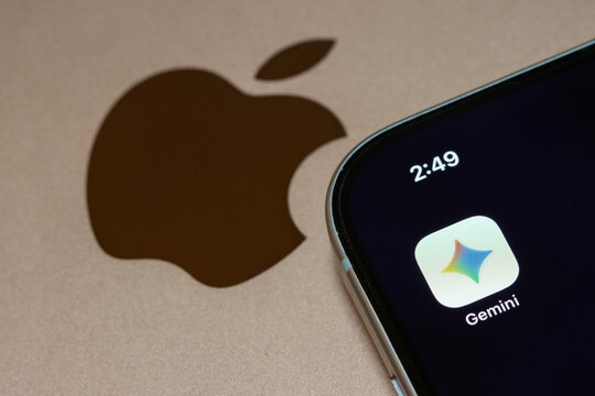 Portland, OR, USA - Jan 14, 2026: Google Gemini app icon is seen on the screen of an iPhone placed on top of a MacBook. Apple will incorporate Google Gemini AI models for Siri.