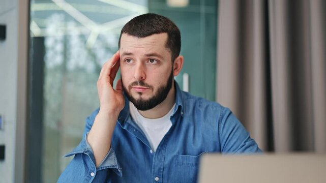 Individual feels stressed and worried while concentrating on laptop. Evident are symptoms of headache, frustration, and deep thought. Complex problem-solving requires careful consideration and effort.