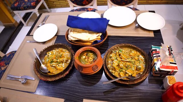 Traditional Indian Meal Setup &ndash; Paneer Curries and Naan on Dining Table