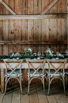 Formal table setting with flowers in a rustic barn, rehearsal dinner
