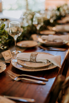 Plates, silverware, wine glass and napkin with ring on dinner table