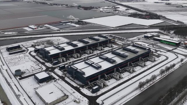 Aerial drone video of a large-scale computing and datacenter facility in winter, showcasing telecommunications infrastructure, server systems, and high-capacity digital operations.