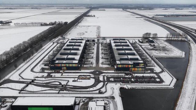 Aerial drone video of a large-scale computing and datacenter facility in winter, showcasing telecommunications infrastructure, server systems, and high-capacity digital operations.