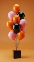 Vibrant orange pink and black balloons tied to a brown cube on an orange background symbolizing celebration and festivity