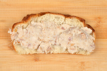 A single slice of crusty bread topped with a thick layer of traditional savory pork lard spread known as zaseka on a wooden background