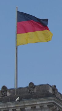Vertical View of German Flag Waving on Historic Stone Building