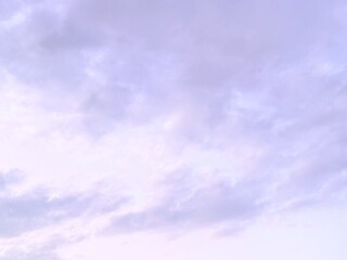 White clouds float in a purple sky; this can be used as a background image.