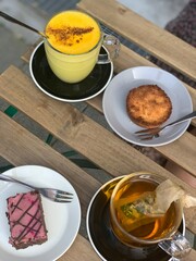 Cozy Cafe Table with Golden Latte, Tea and Desserts in Denmark; Scandinavian Cafe Treats with Turmeric Latte, Tea and Desserts