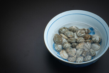 器の中に塩水と一緒に入れられた、砂抜き中のあさり