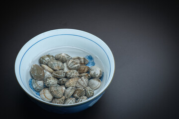 器の中に塩水と一緒に入れられた、砂抜き中のあさり