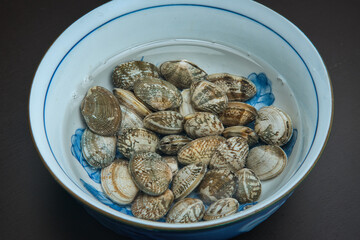 器の中に塩水と一緒に入れられた、砂抜き中のあさり