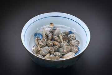 器の中に塩水と一緒に入れられた、砂抜き中のあさり