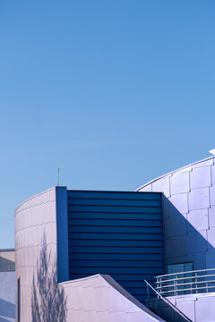 Modern architecture facade in blue frames a minimal building corner with clear sky and sharp geometry for clean urban exterior design