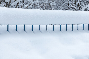 Close-up of a metal fence covered in deep snow